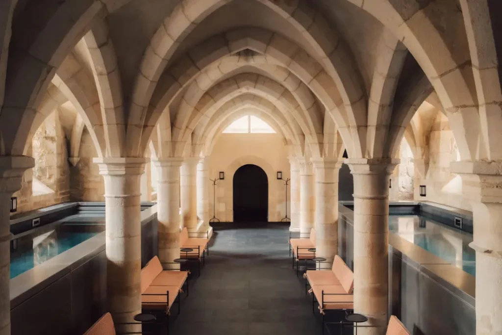 Le spa des Sources de Vougeot sous les voûtes séculaires de l'ancien cellier du château de Gilly avec son bassin de relaxation et son bassin de nage.