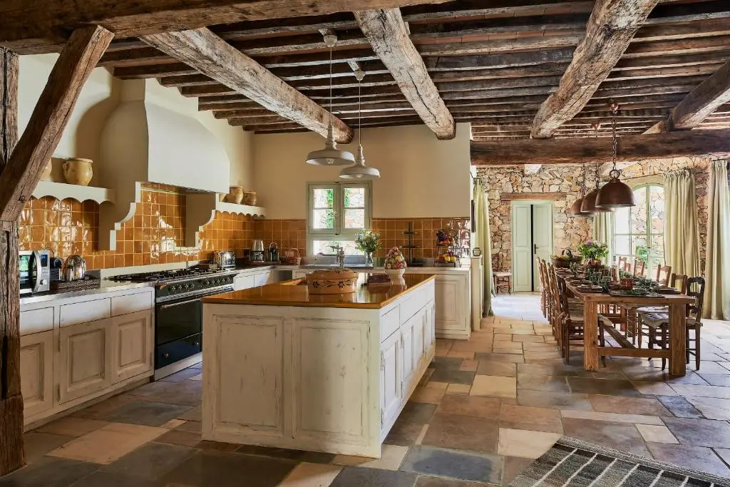 Vue sur la cuisine, son plan de travail et la table à manger dans la villa Vanado dans l'hôtel Château de Berne en Provence.