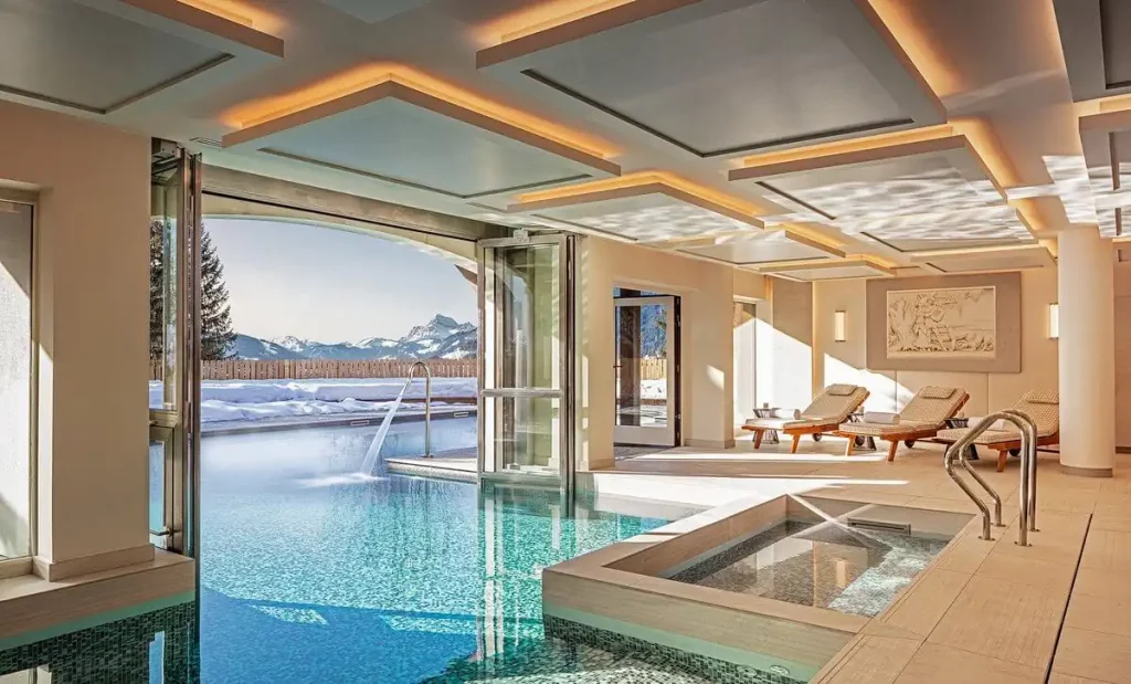Le spa du Chalet des Mont d'Arbois, ouvert sur l'extérieur avec les sommets enneigés en arrière-plan.