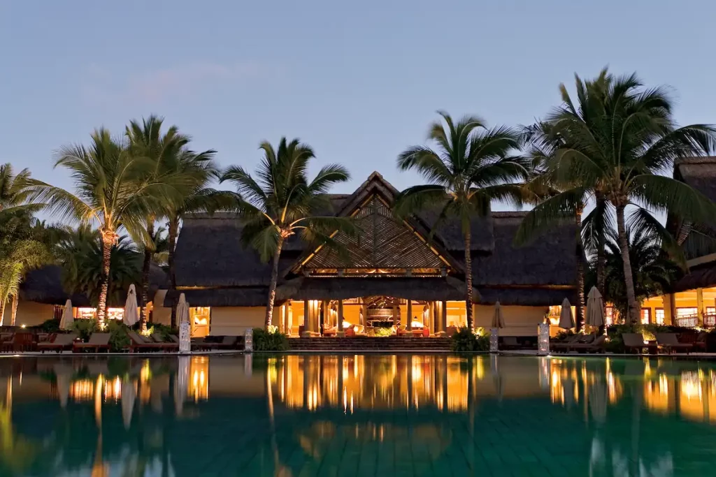 La piscine de l'hôtel Constance Prince Maurice à la tombée de la nuit.