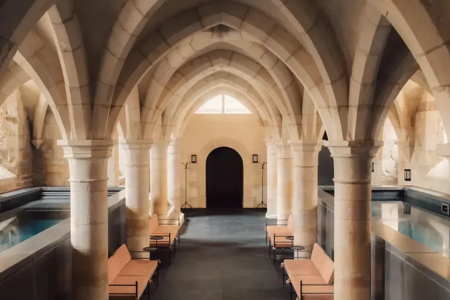 Le spa des Sources de Vougeot sous les voûtes séculaires de l'ancien cellier du château de Gilly avec son bassin de relaxation et son bassin de nage.