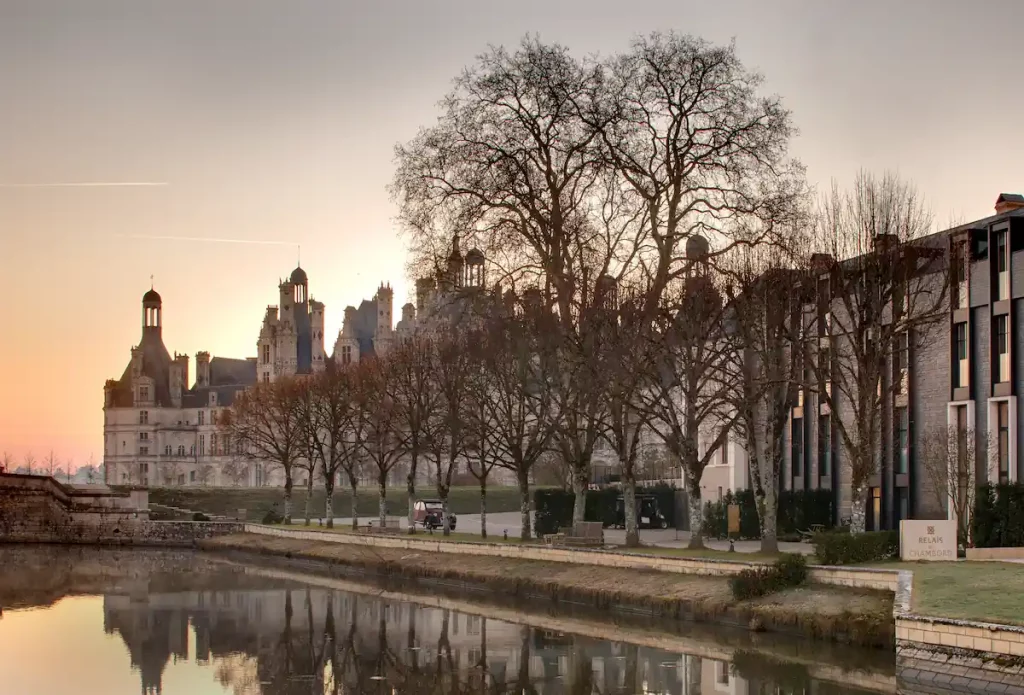 Vue extérieure de l'hôtel Relais de Chambord avec le château de Chambord en arrière-fond.