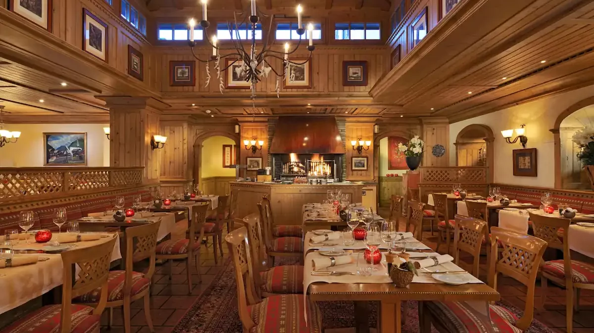 La salle du grill le Cervin avec sa cheminée centrale au Mont Cervin Palace.