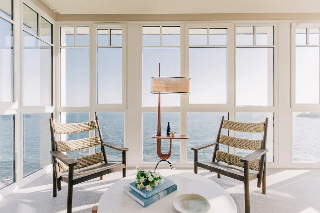 Un salon de l'hôtel Les Bassans, fauteuils en corde tressée et baies panoramiques sur la mer, dans l'esprit paquebot des années trente.