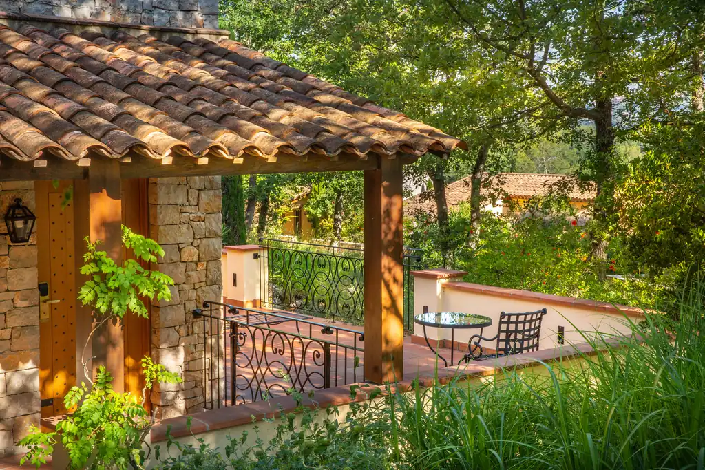 Terrasse privative d'une suite de Terre Blanche, toit en tuiles et murs de pierre au cœur du jardin méditerranéen