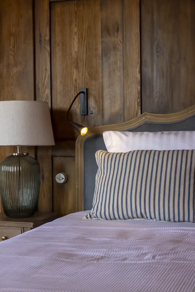 Chambre aux boiseries et literie en lin rayé au Hameau de Saparale.