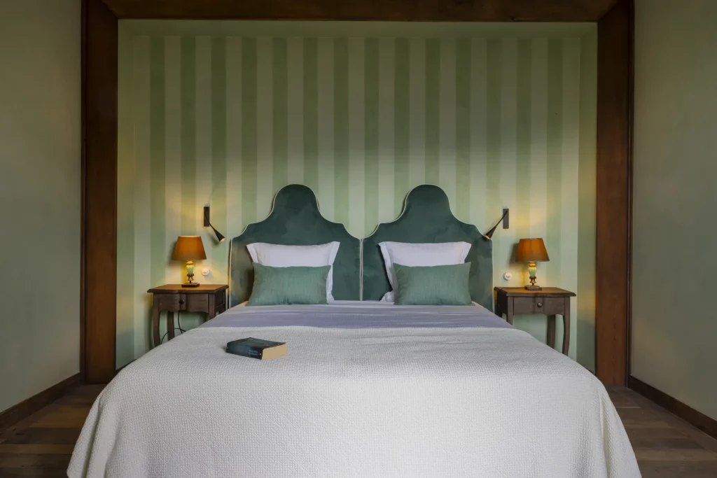 Chambre aux têtes de lit en velours vert et papier peint rayé au Hameau de Saparale.
