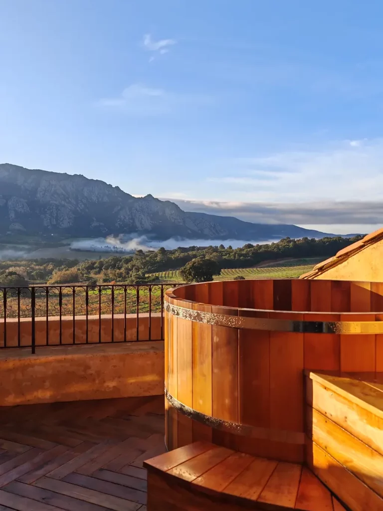 Bain en bois du Spa Sauvage face aux vignes et à la montagne au lever du jour, Hameau de Saparale.